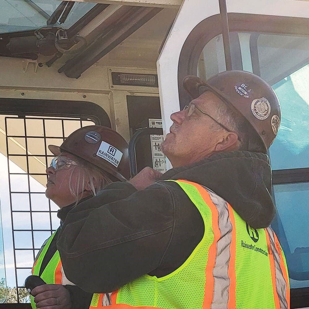 Rainwater crew member Maryna Hudgins operating a skid steer